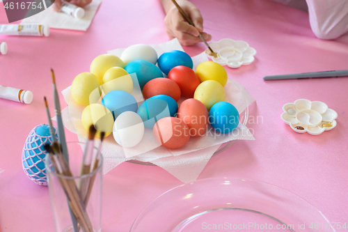 Image of Coloring Easter eggs, multi-colored eggs in the middle of the table