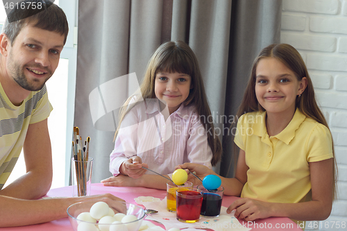 Image of The children, together with dad, painted the first Easter eggs and looked joyfully into the frame