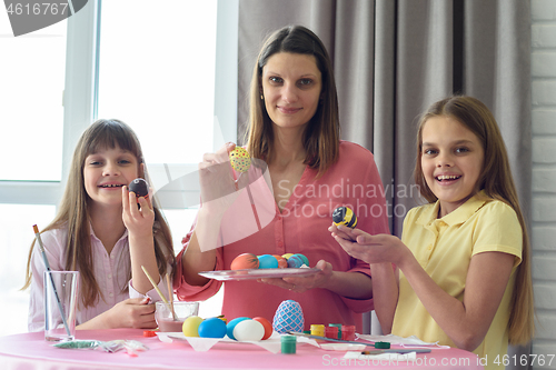 Image of Mom and children show what beautiful Easter eggs they got