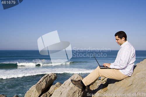 Image of Working with the laptop at the beach