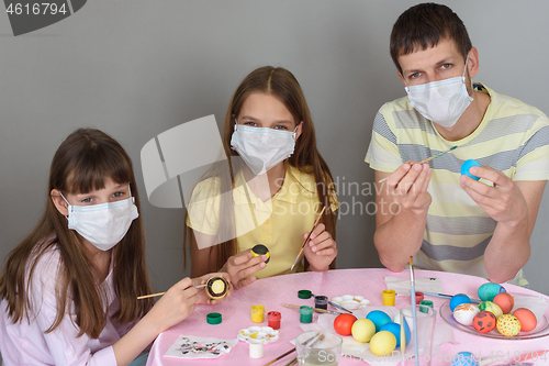 Image of Dad and two quarantined girls paint Easter eggs