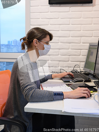 Image of A sick quarantined girl works at a computer