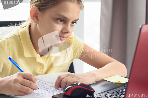 Image of Portrait of a cute girl at the laptop engaged in distance learning