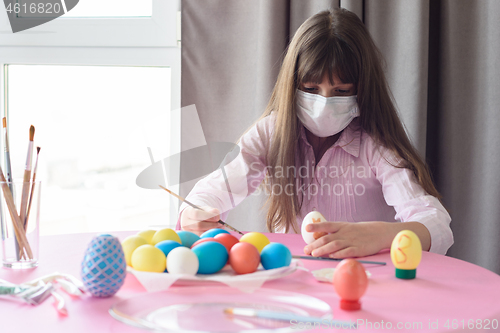 Image of Quarantine-infected girl alone paints Easter eggs