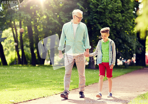 Image of grandfather and grandson walking at summer park