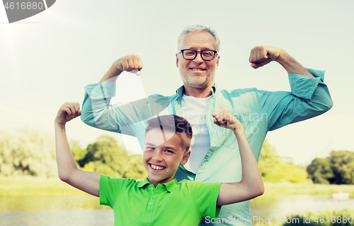 Image of happy grandfather and grandson showing muscles