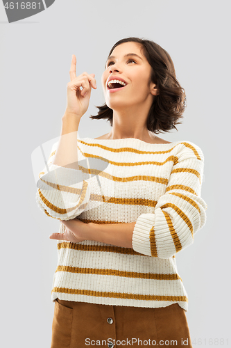 Image of woman in striped pullover pointing her finger up