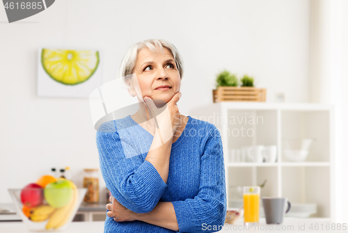 Image of portrait of senior woman thinking in kitchen