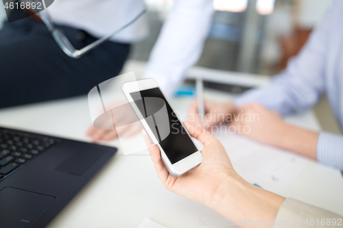 Image of business team with smartphone working at office