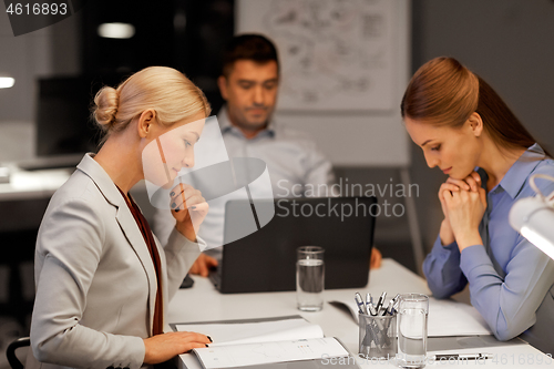 Image of business team with laptop working at night office