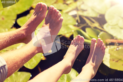 Image of grandfather and grandson feet over river