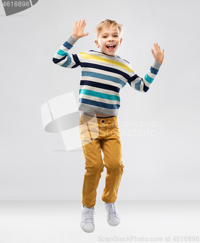 Image of happy little boy jumping and having fun