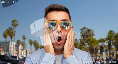 Image of surprised man in sunglasses over venice beach