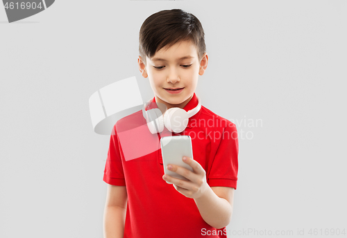 Image of boy in red t-shirt with headphones and smartphone