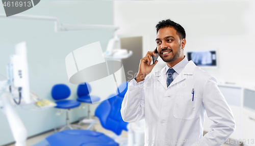 Image of dentist calling on smartphone at dental clinic