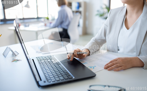 Image of businesswoman with laptop working at office