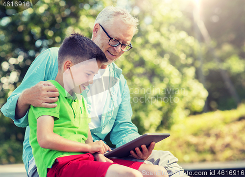 Image of happy grandfather and boy with tablet pc outdoors