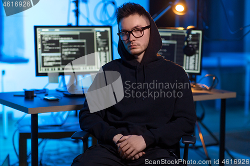 Image of asian hacker in dark room with computers at night