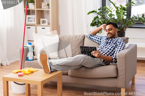 Image of man with tablet computer after home cleaning