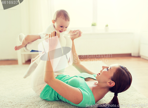 Image of happy mother playing with baby at home