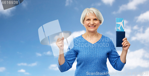 Image of senior woman with passport and airplane ticket