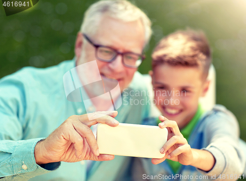 Image of old man and boy taking selfie by smartphone