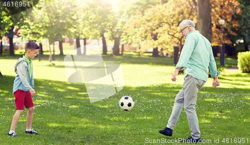 Image of old man and boy playing football at summer park