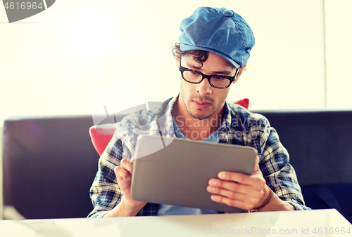 Image of man with tablet pc sitting at cafe table