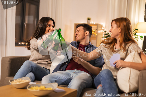 Image of friends playing cards and drinking beer at home