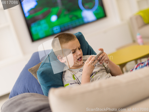 Image of little boy playing games on smartphone