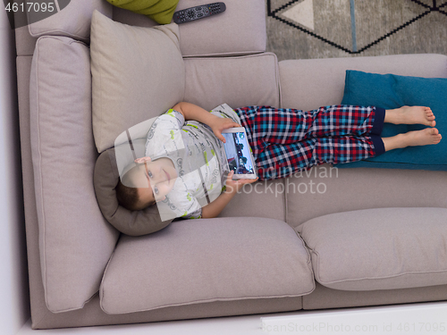 Image of top view of  little boy playing games on tablet computers