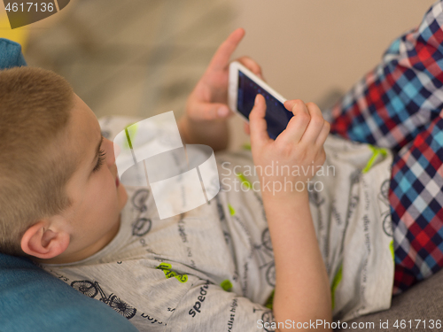 Image of little boy playing games on smartphone