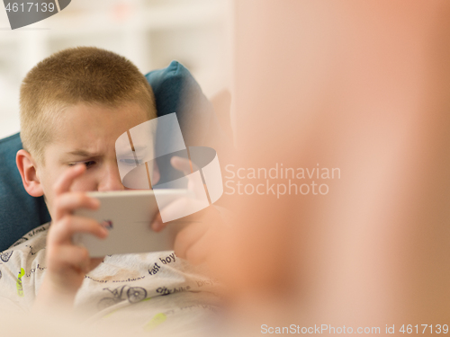 Image of little boy playing games on smartphone