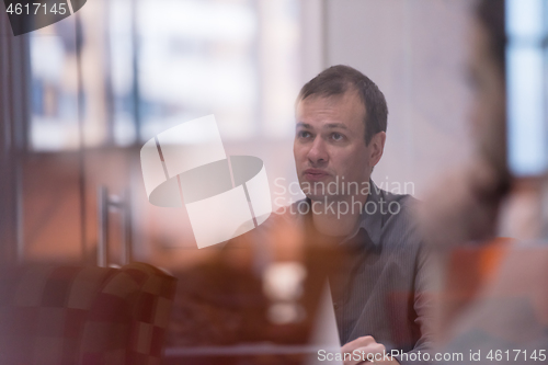 Image of businessman working using a laptop in startup office