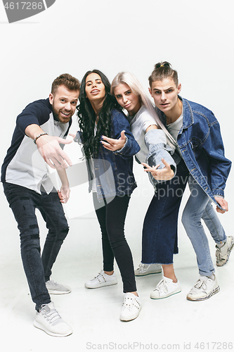 Image of Group of smiling friends in fashionable jeans