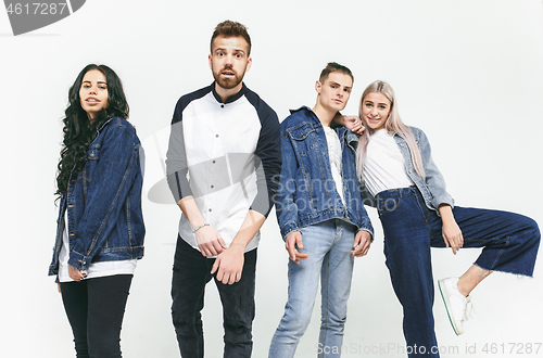 Image of Group of smiling friends in fashionable jeans