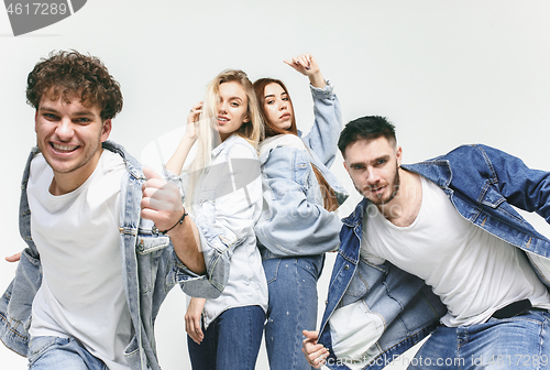 Image of Group of smiling friends in fashionable jeans