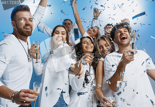 Image of Group of cheerful joyful young people standing and celebrating together over blue background