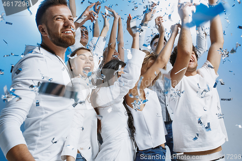 Image of Group of cheerful joyful young people standing and celebrating together over blue background