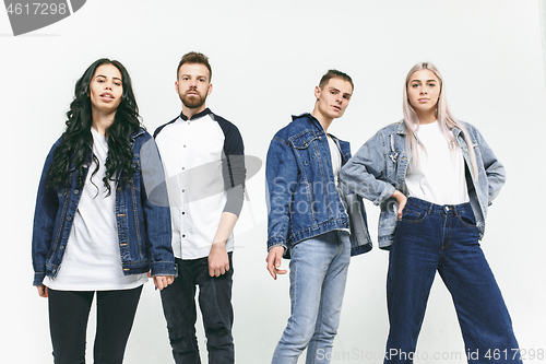 Image of Group of smiling friends in fashionable jeans