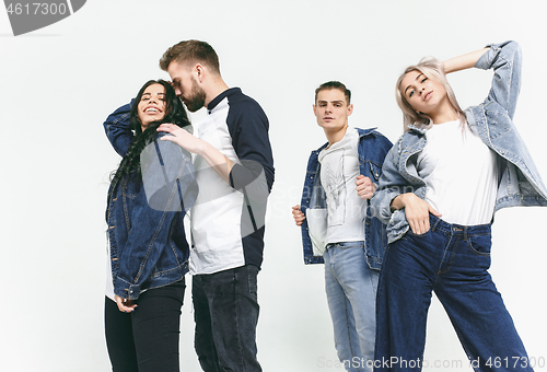 Image of Group of smiling friends in fashionable jeans