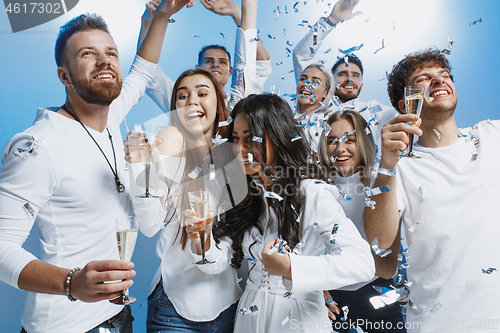 Image of Group of cheerful joyful young people standing and celebrating together over blue background