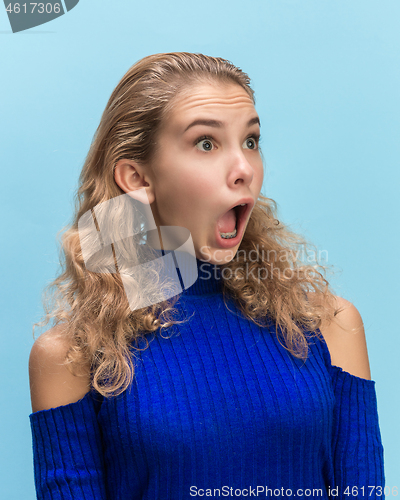 Image of The woman screaming with open mouth isolated on blue background, concept face emotion