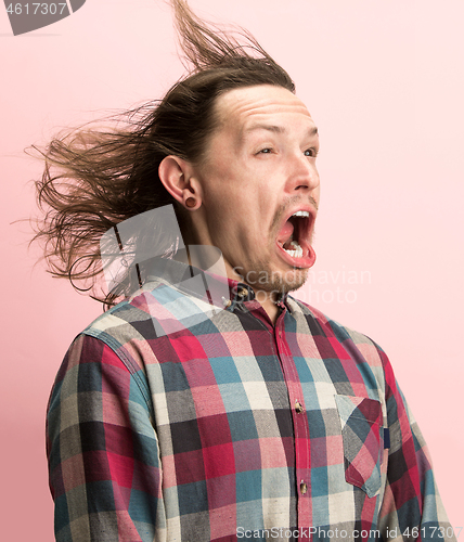 Image of The man screaming with open mouth isolated on pink background, concept face emotion