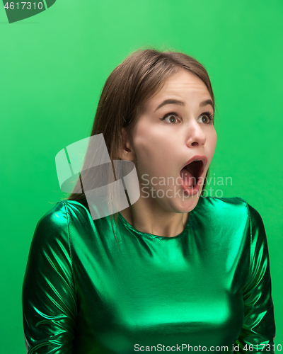 Image of The woman screaming with open mouth isolated on green background, concept face emotion