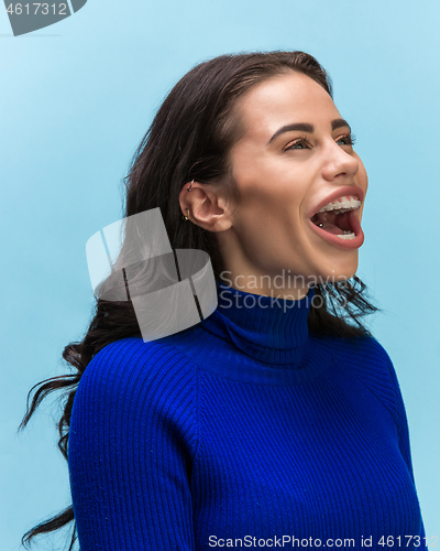 Image of The woman screaming with open mouth isolated on blue background, concept face emotion