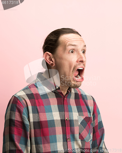 Image of The man screaming with open mouth isolated on pink background, concept face emotion