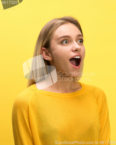 Image of The woman screaming with open mouth isolated on yellow background, concept face emotion