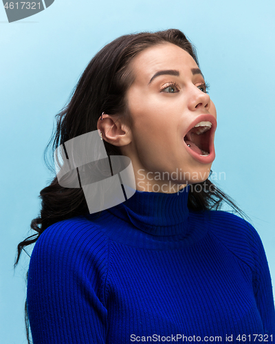 Image of The woman screaming with open mouth isolated on blue background, concept face emotion