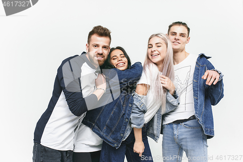 Image of Group of smiling friends in fashionable jeans